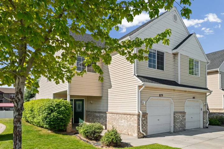 Two-story residence featuring light and t-toned siding, a dark green entry door with decorative glass.