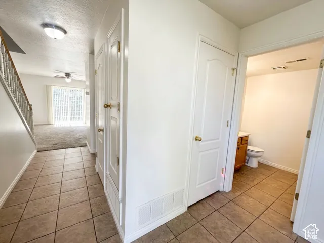 Tiled entry with staircase, white paneled doors, and ceiling-mounted light fixture