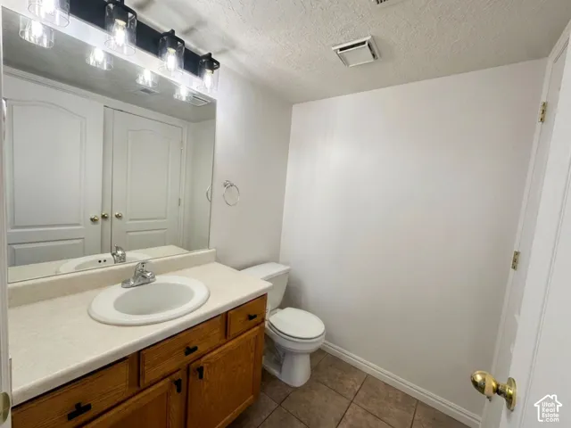 Half Bathroom with vanity and a single basin sink, laminate countertop, and wood-finish cabinetry