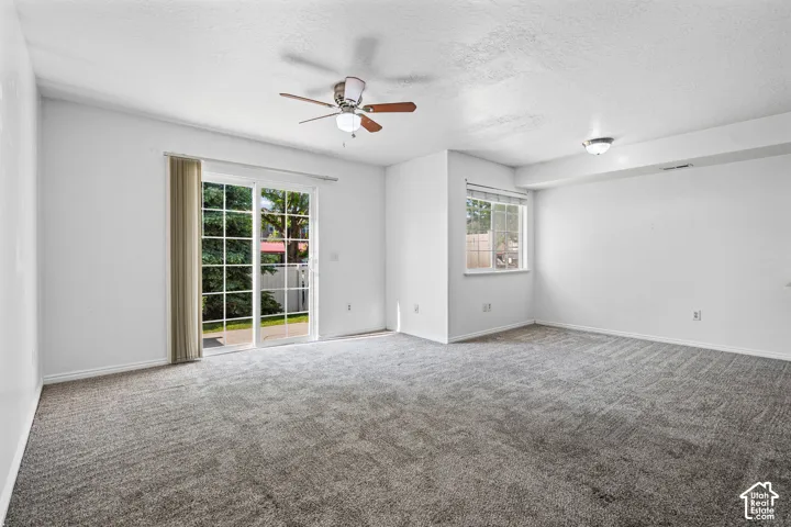 Spacious room featuring neutral carpeting and white painted walls