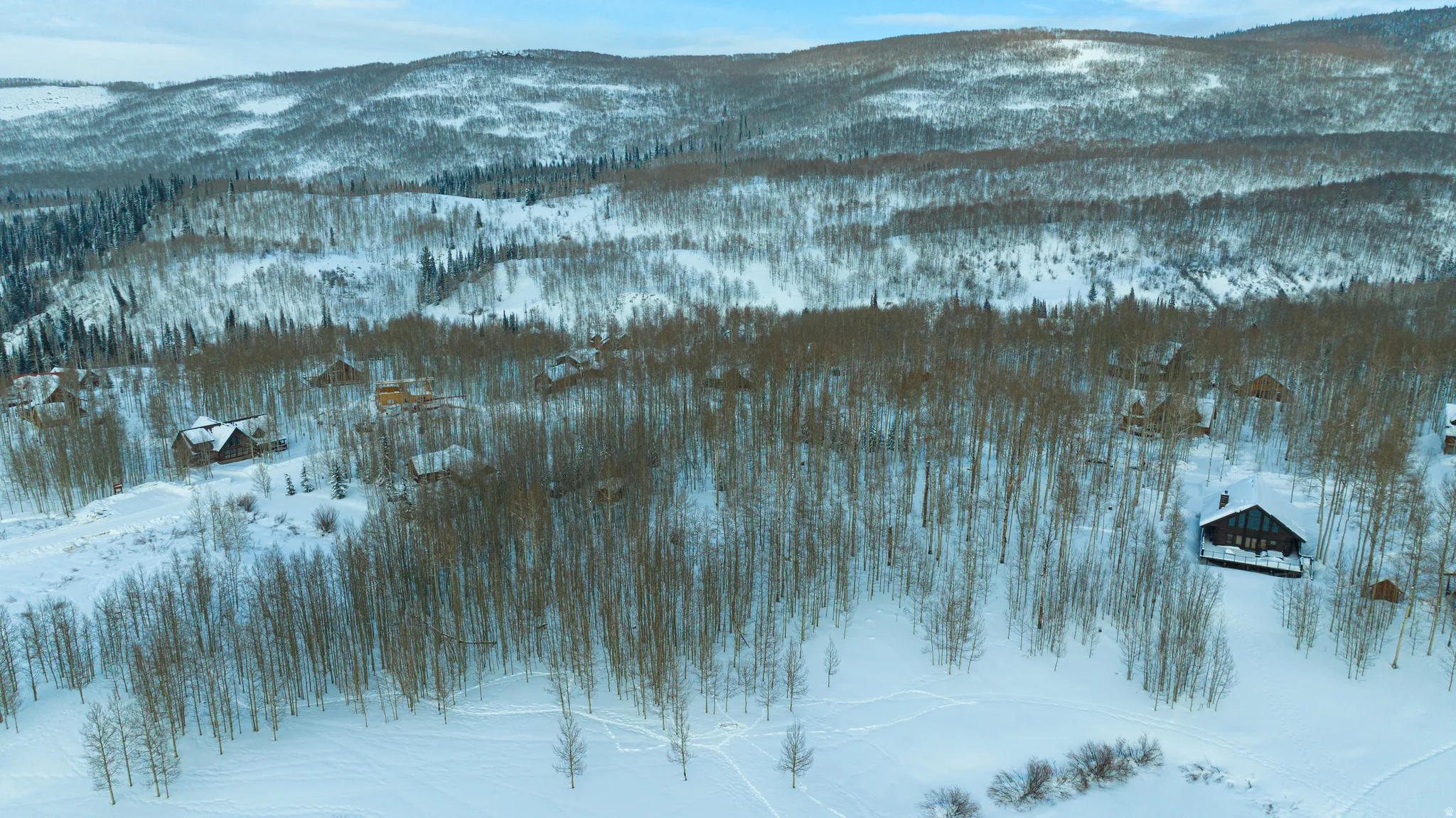 Winter landscape with snow-covered terrain and forested hillsides