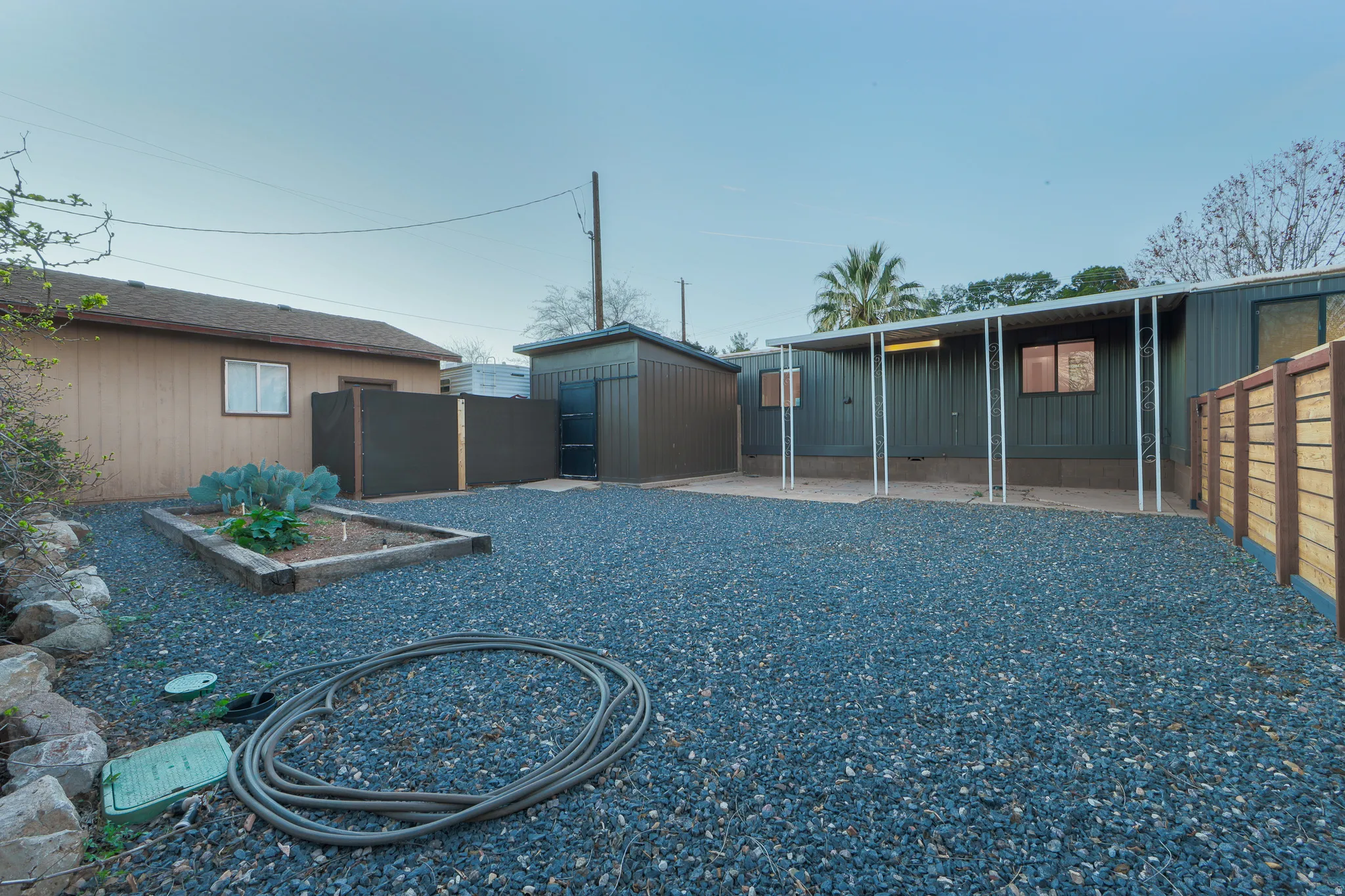 Rear view of property featuring a fenced backyard, a vegetable garden, and an outdoor structure