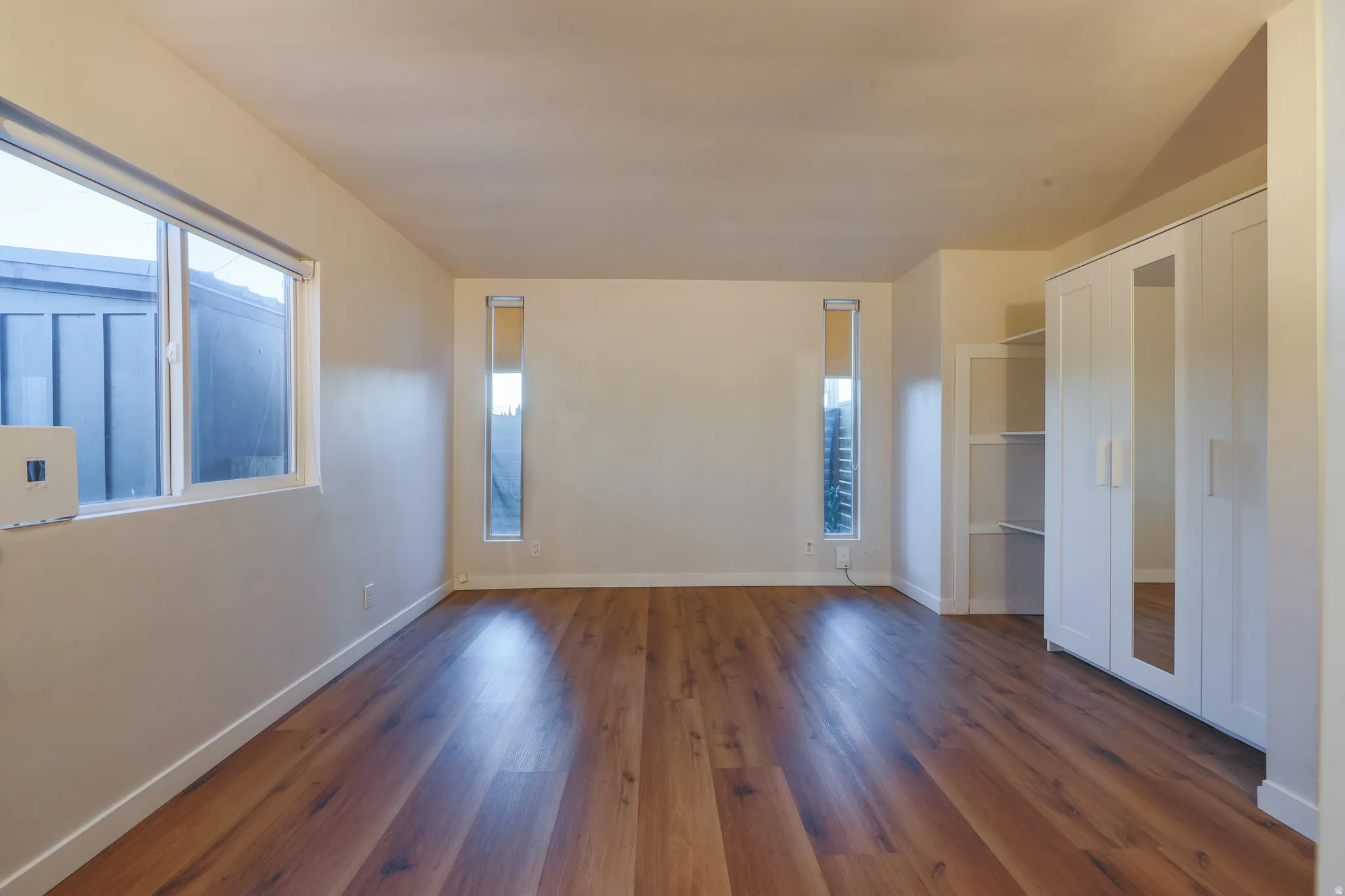 Unfurnished bedroom featuring dark wood finished floors and a closet