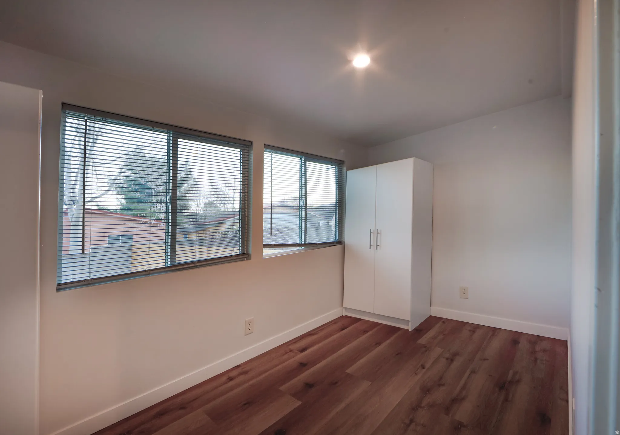 Unfurnished bedroom with dark wood-style flooring and a closet