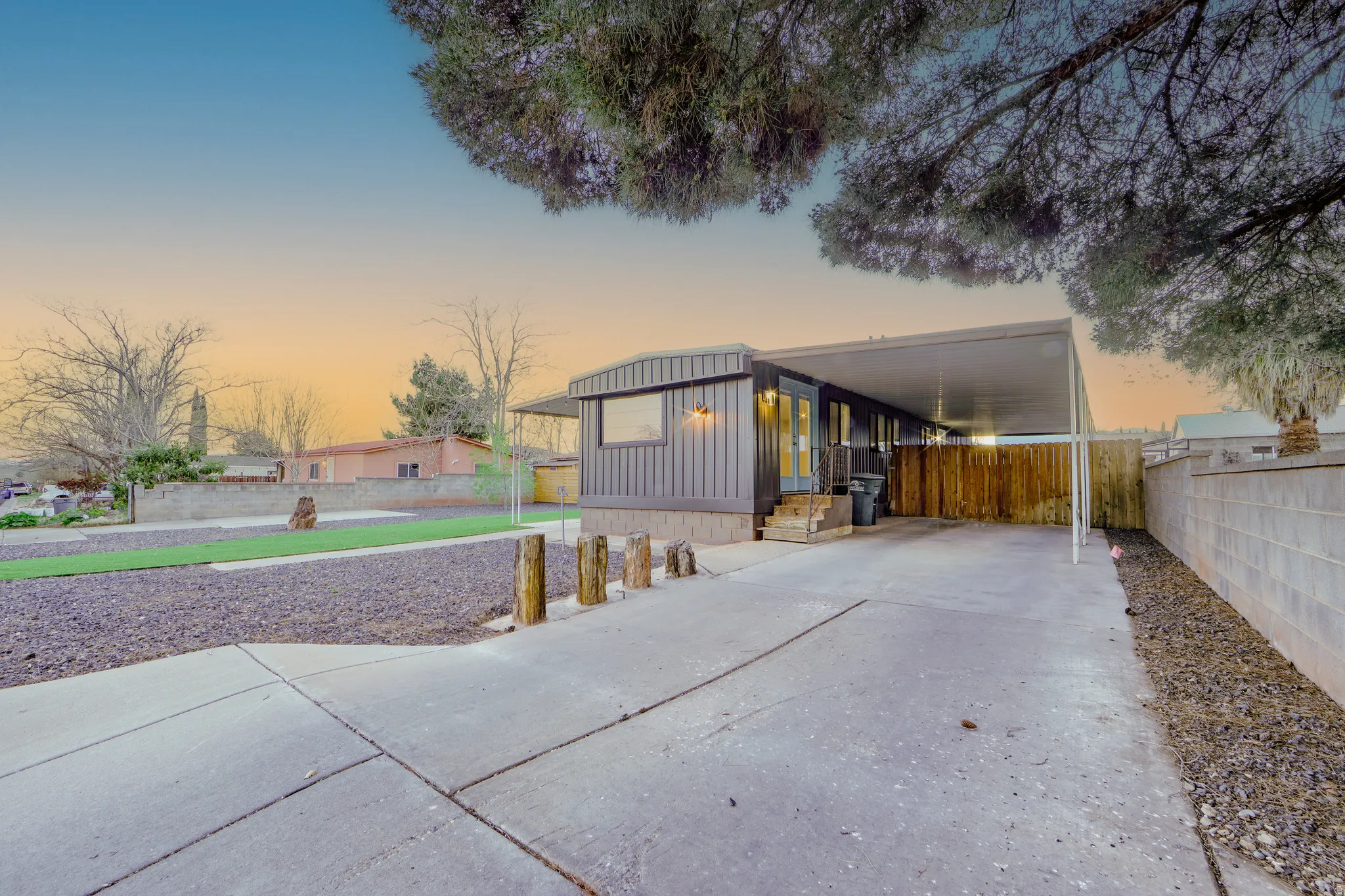 View of front facade with an attached carport, board and batten siding, and driveway