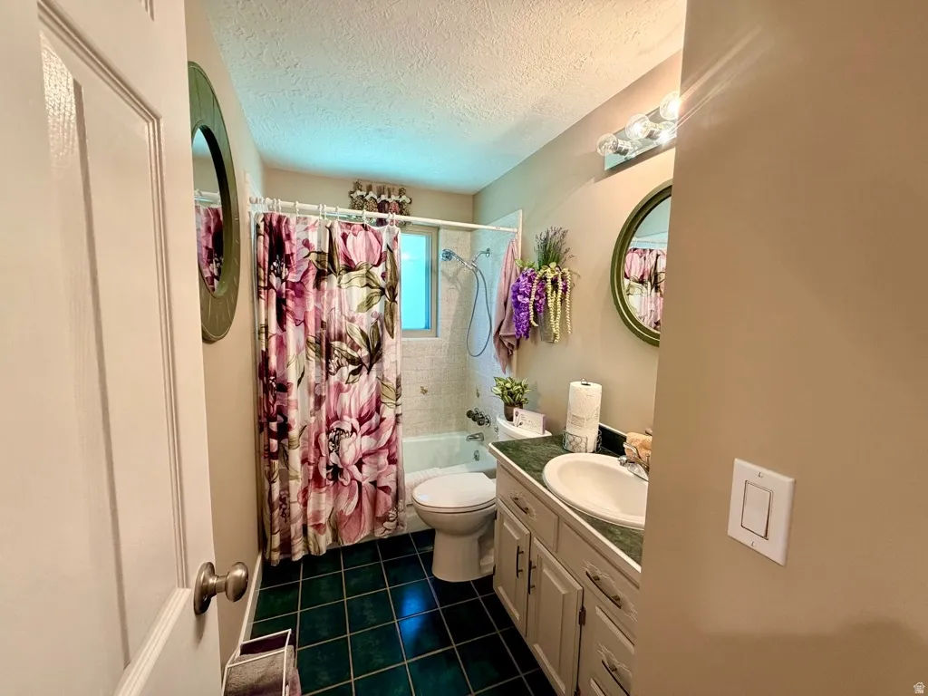 Bathroom featuring a single vanity with a white basin sink, green countertop, and white cabinetry