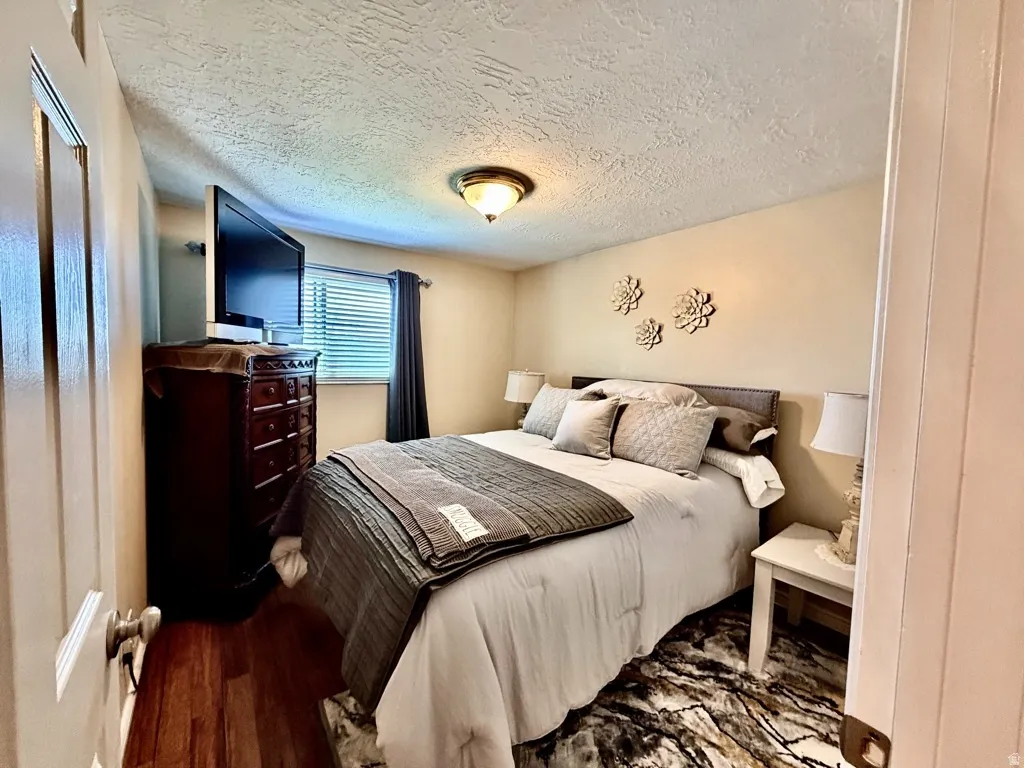Bedroom featuring warm-toned walls and wood-finish flooring