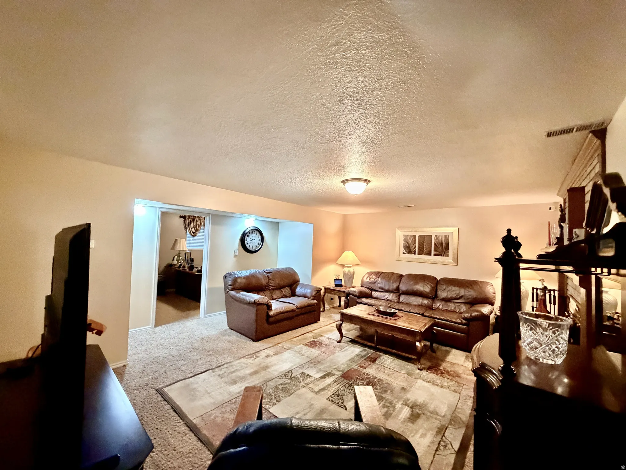 Spacious entertainment room featuring recessed lighting, a neutral wall color, and textured carpeting