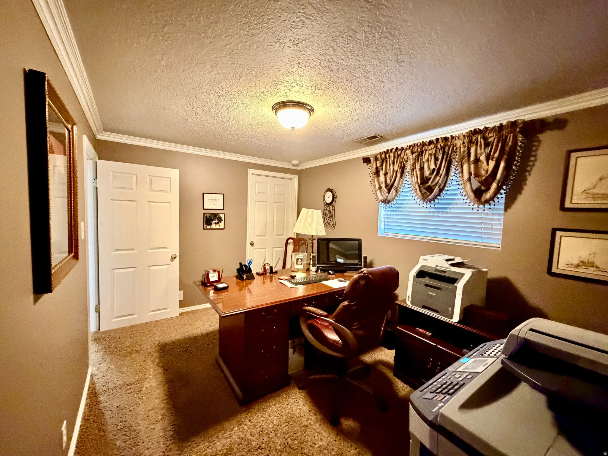 Interior room featuring crown molding, neutral wall color, and textured carpeting