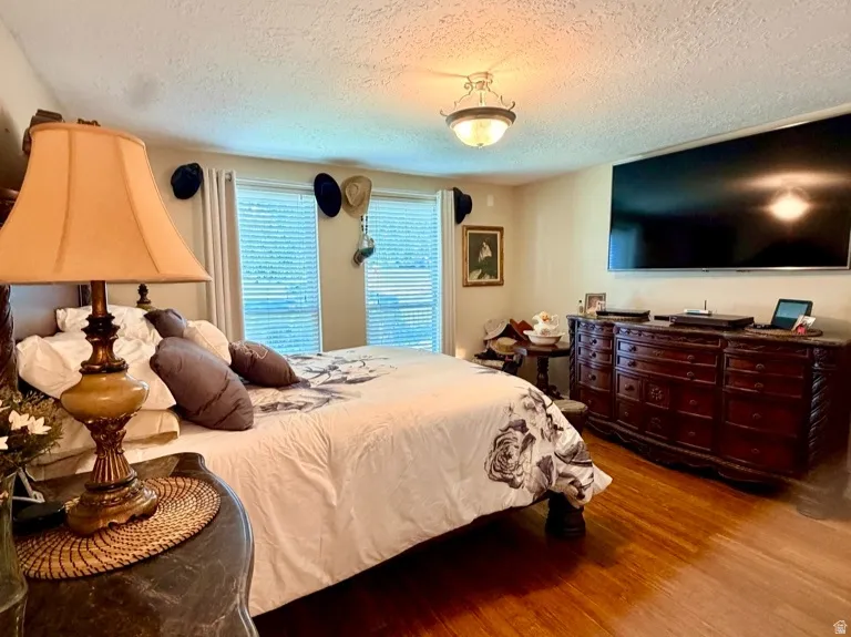 Spacious room featuring wood-finish flooring, textured ceiling, and built-in lighting