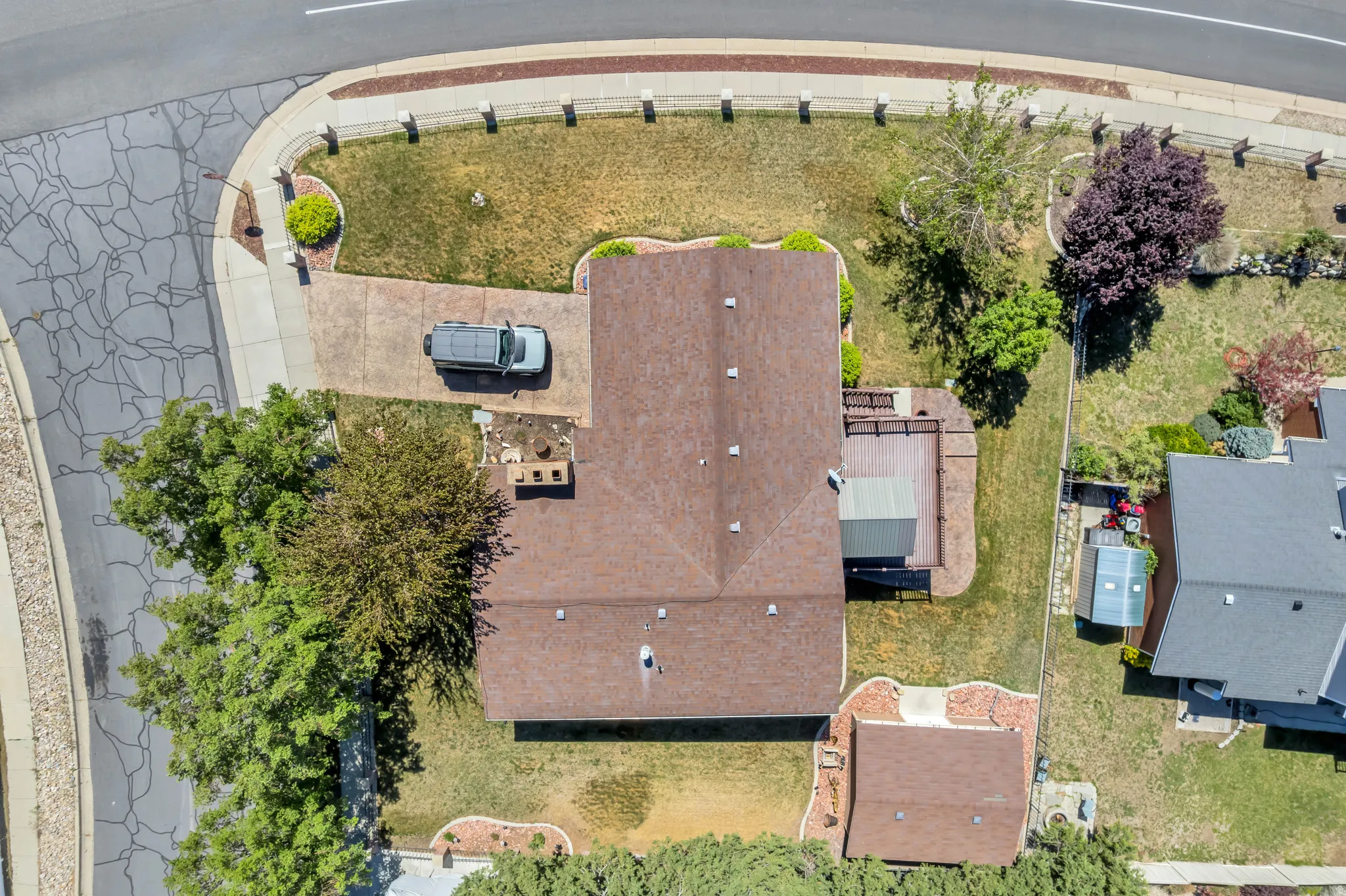Property featuring a brown shingle roof, a front-facing driveway with concrete paving, and a rear wood-plank deck