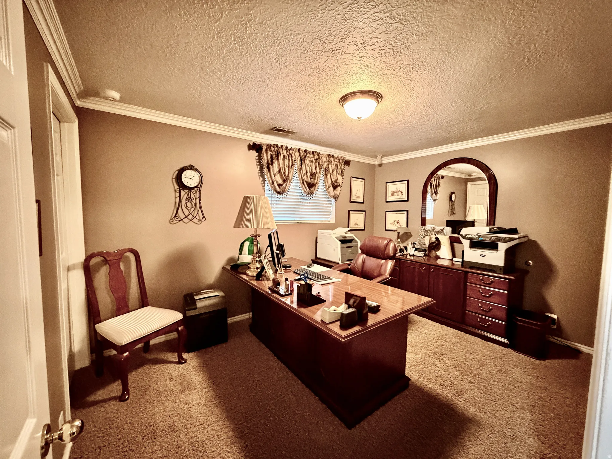 Dedicated room featuring a textured ceiling, crown molding, and neutral wall tones