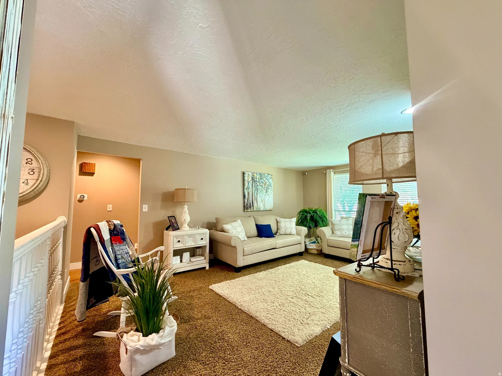 Inviting living area featuring neutral wall tones, and plush carpeting