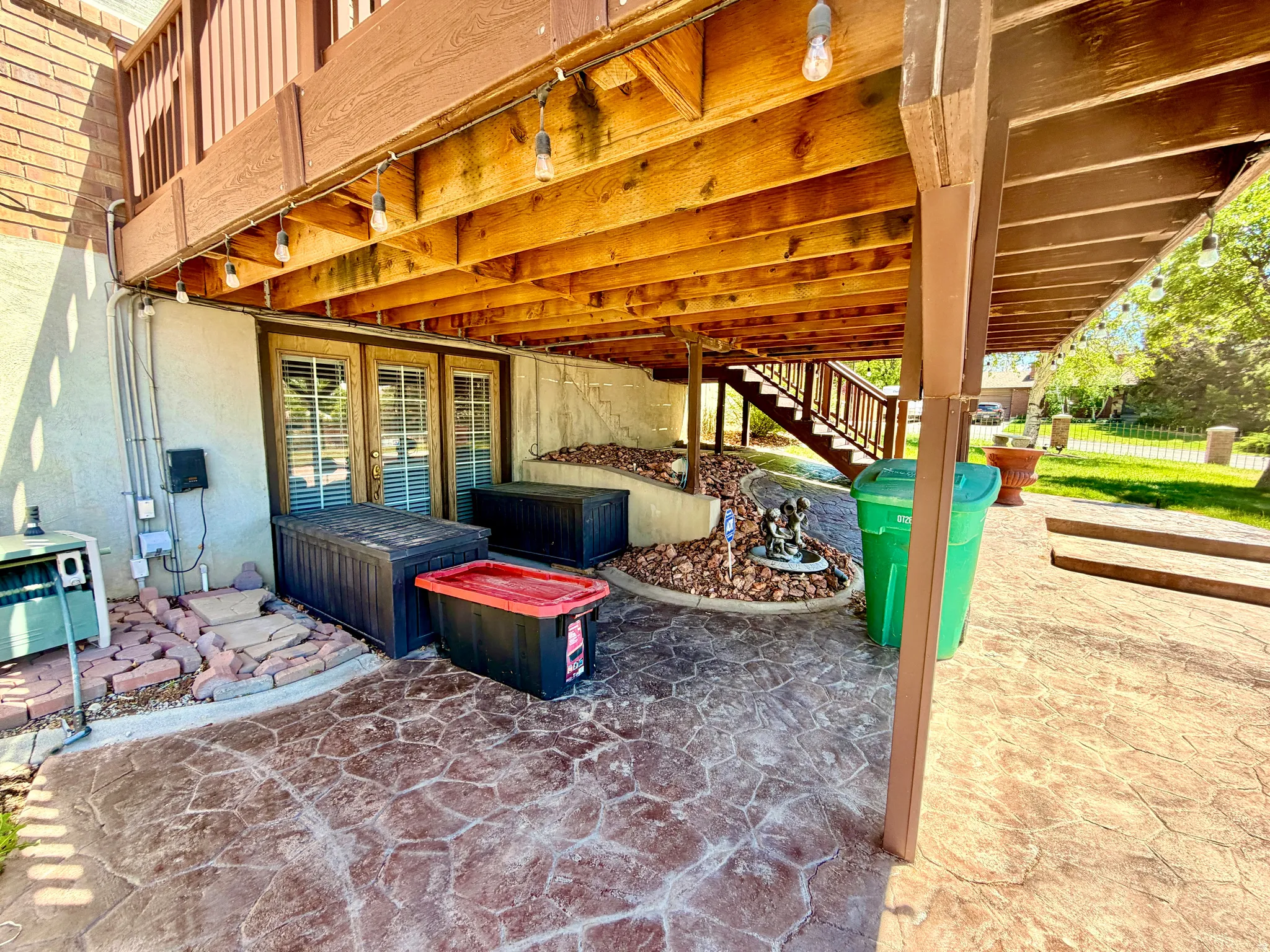 Spacious under-deck patio area with stamped concrete flooring