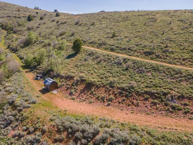 Expansive undeveloped land featuring rolling hills with scattered trees and shrubs