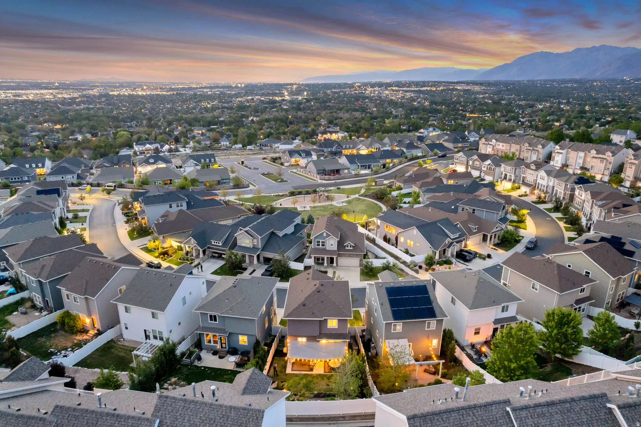 Expansive residential neighborhood featuring a variety of single-family homes, curved roadways, and distant mountain scenery