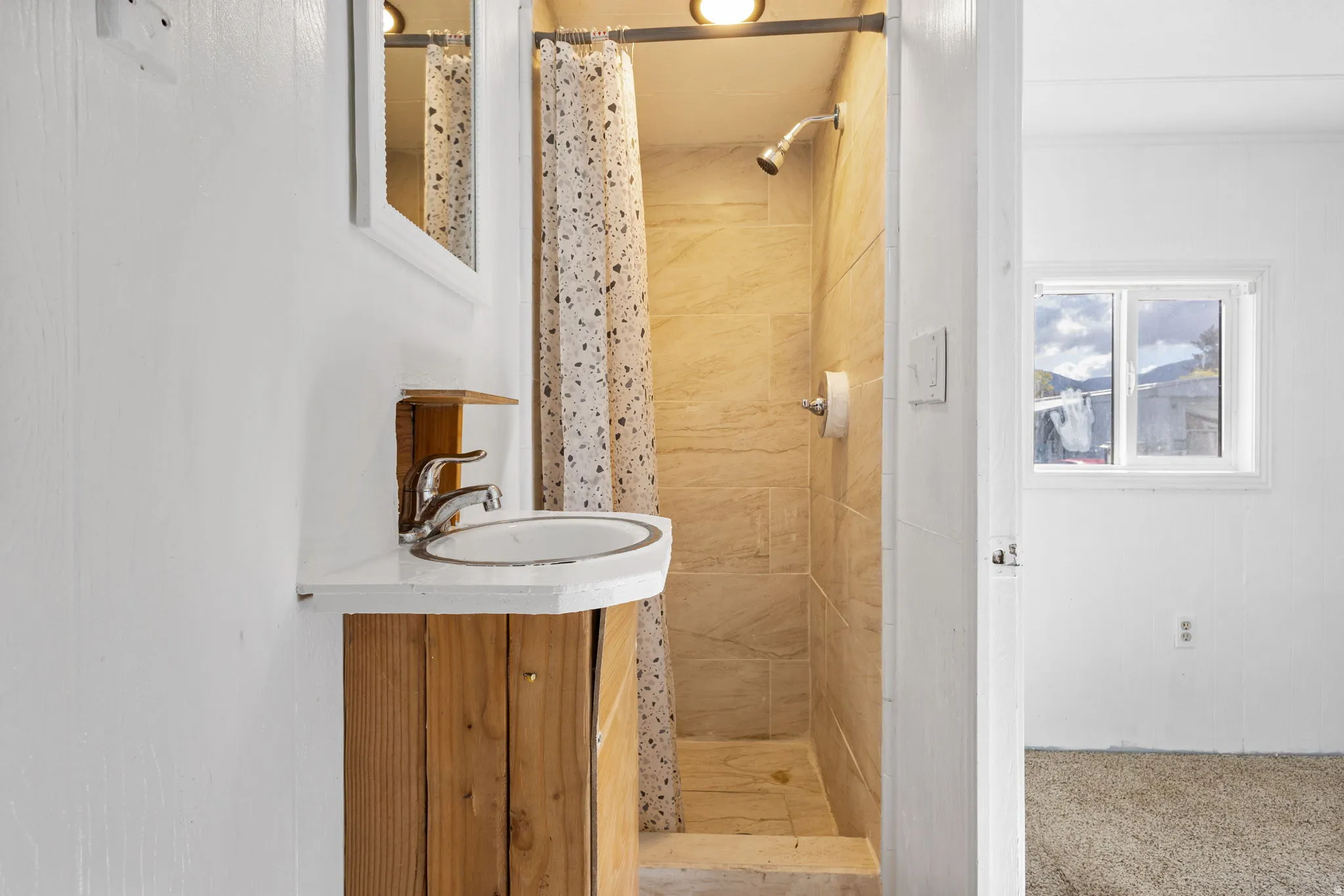 Bathroom vanity featuring a circular basin sink and a chrome faucet