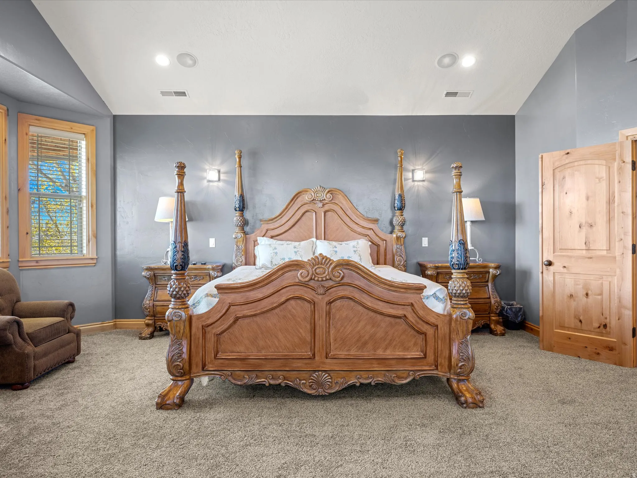 Spacious room featuring gray textured walls, recessed ceiling lighting, and light wood doors with black hardware
