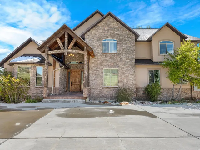 Stone and stucco exterior featuring a prominent timber-framed entryway