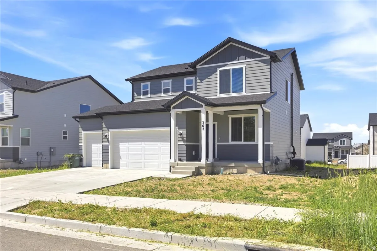 Two-story residence featuring grey horizontal siding with white trim accents and a dark roof
