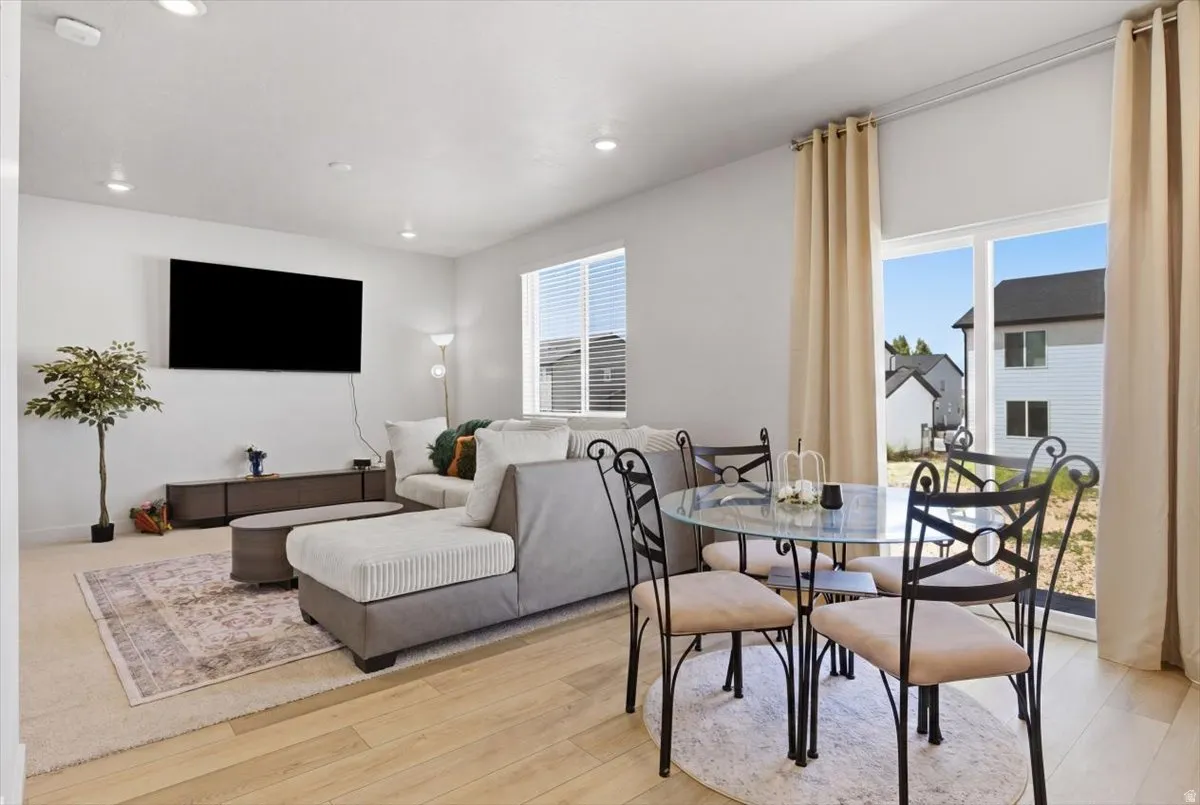 Open-concept living space featuring wood-finish flooring, recessed lighting, and large sliding glass doors