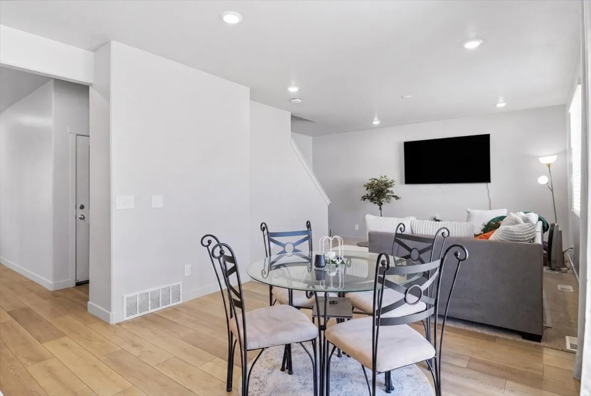 Open-concept living area featuring light wood-finish flooring, recessed ceiling lighting, and a neutral color palette