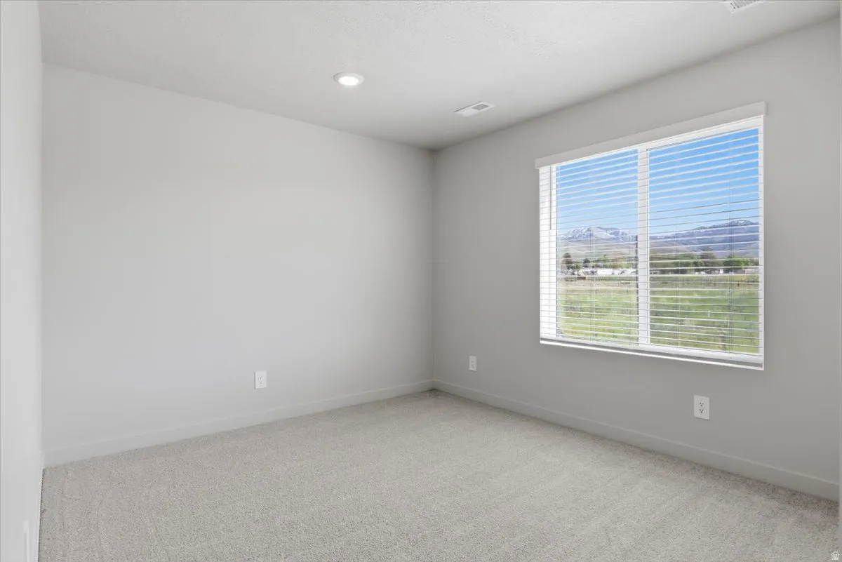 Interior room featuring light gray walls, recessed lighting, and light-colored carpeting