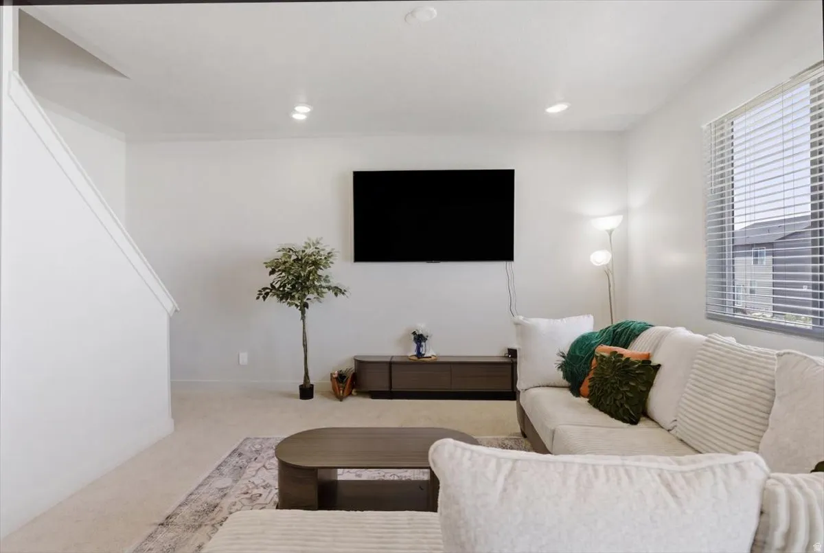 Open-concept living area with neutral wall tones and recessed lighting
