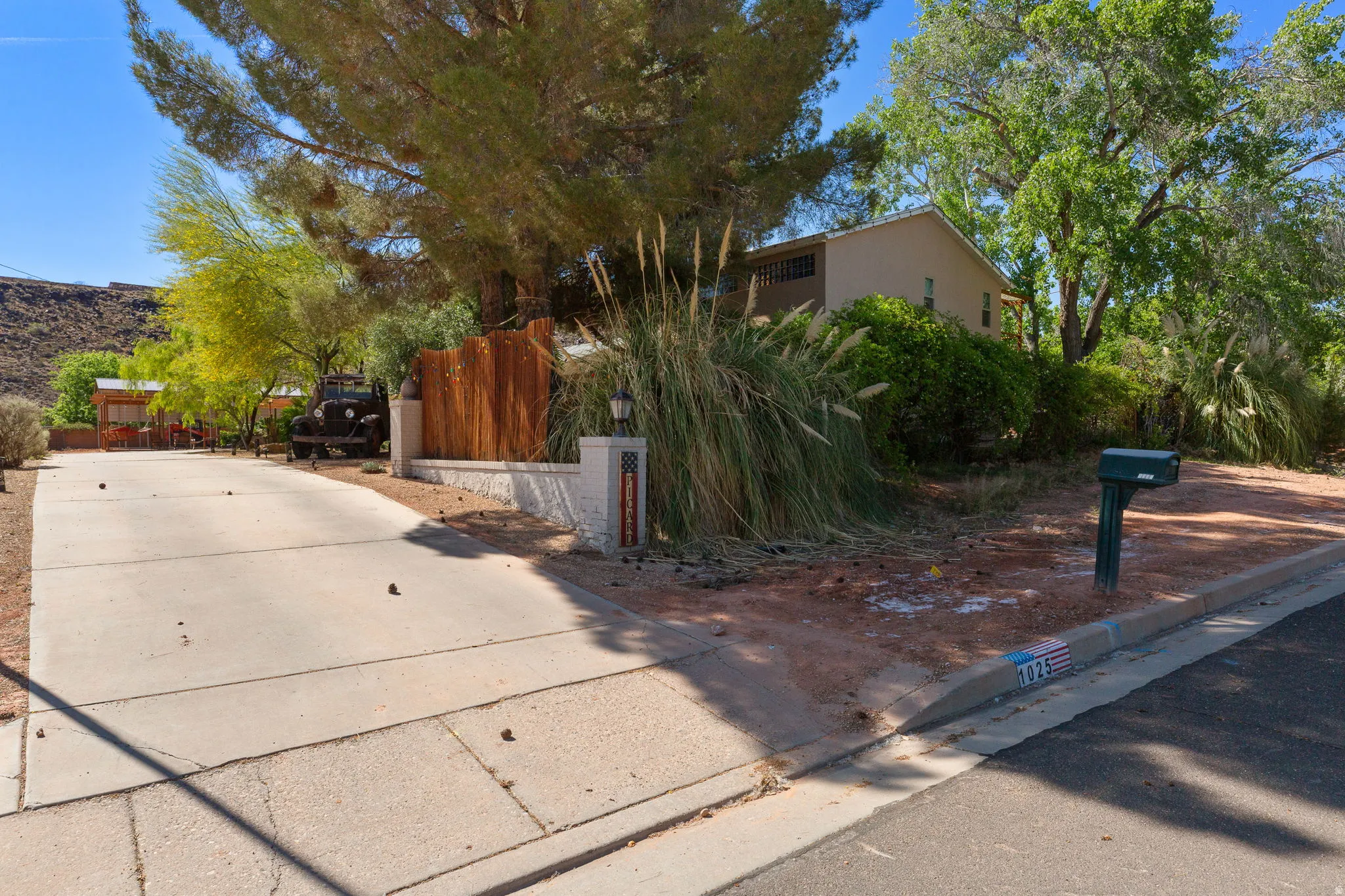 Paved driveway leading to a residence with a light-colored stucco exterior