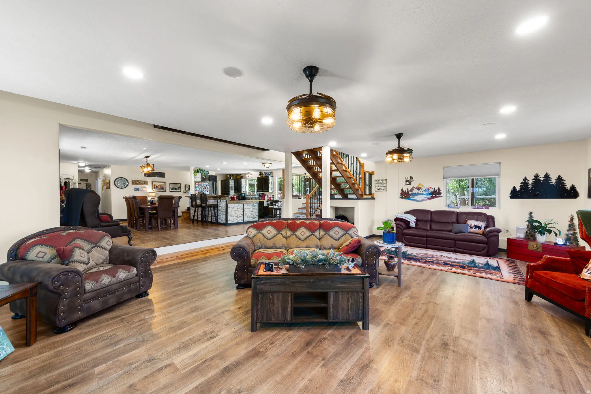 Spacious open-concept interior featuring wood-finish flooring, recessed lighting, and decorative ceiling fans