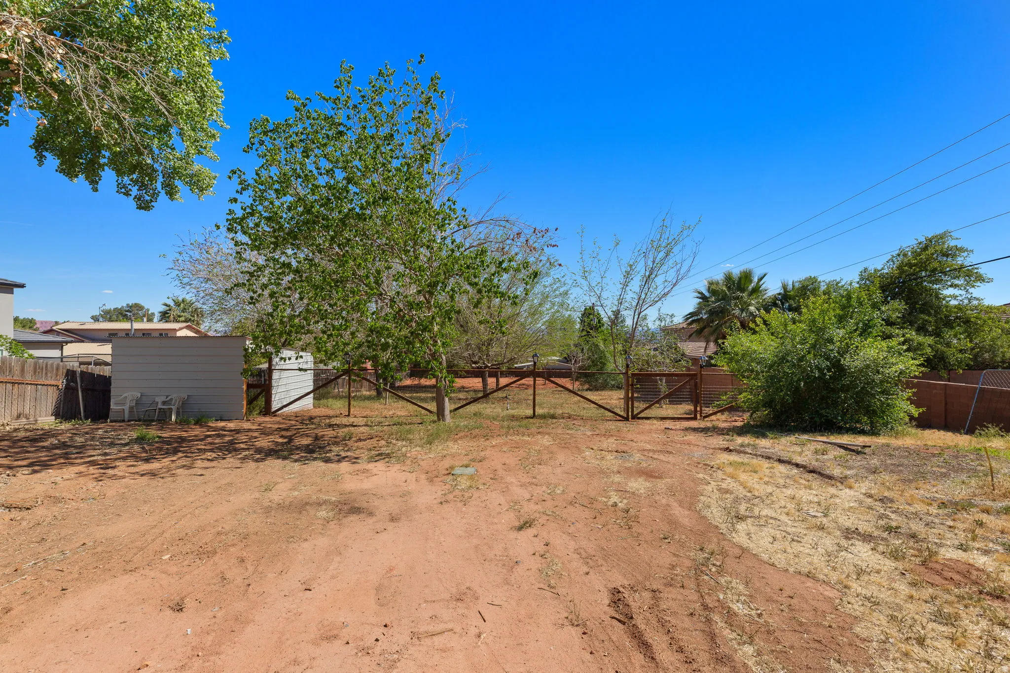 Expansive backyard with a wood fence perimeter and mature trees