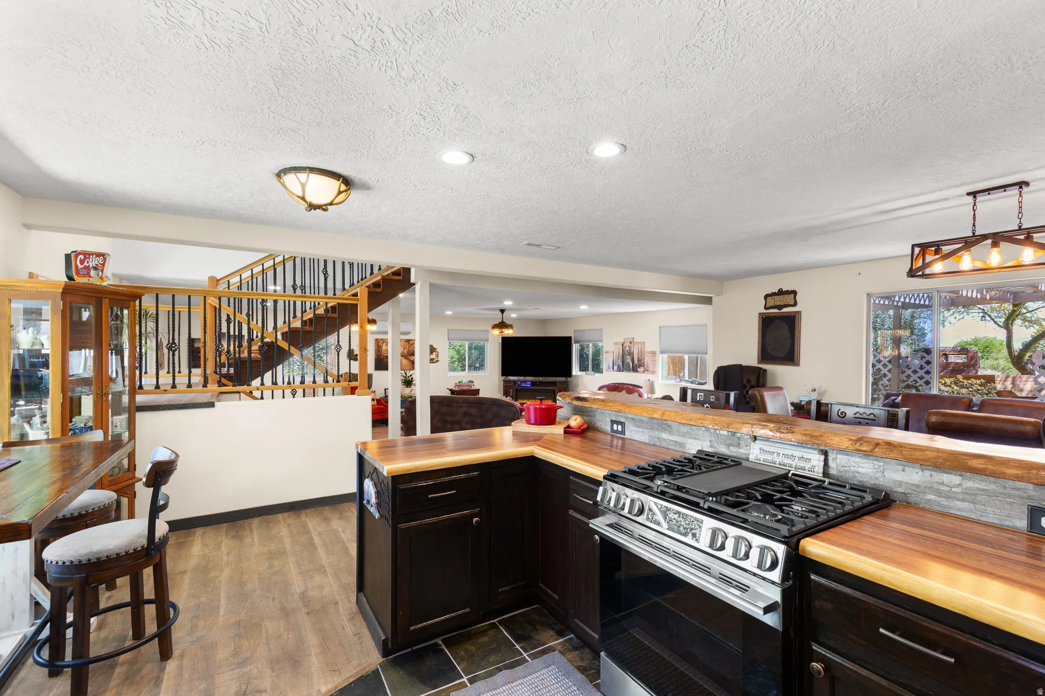 Kitchen featuring rich wood-finish countertops, dark cabinetry, and a stainless steel gas range
