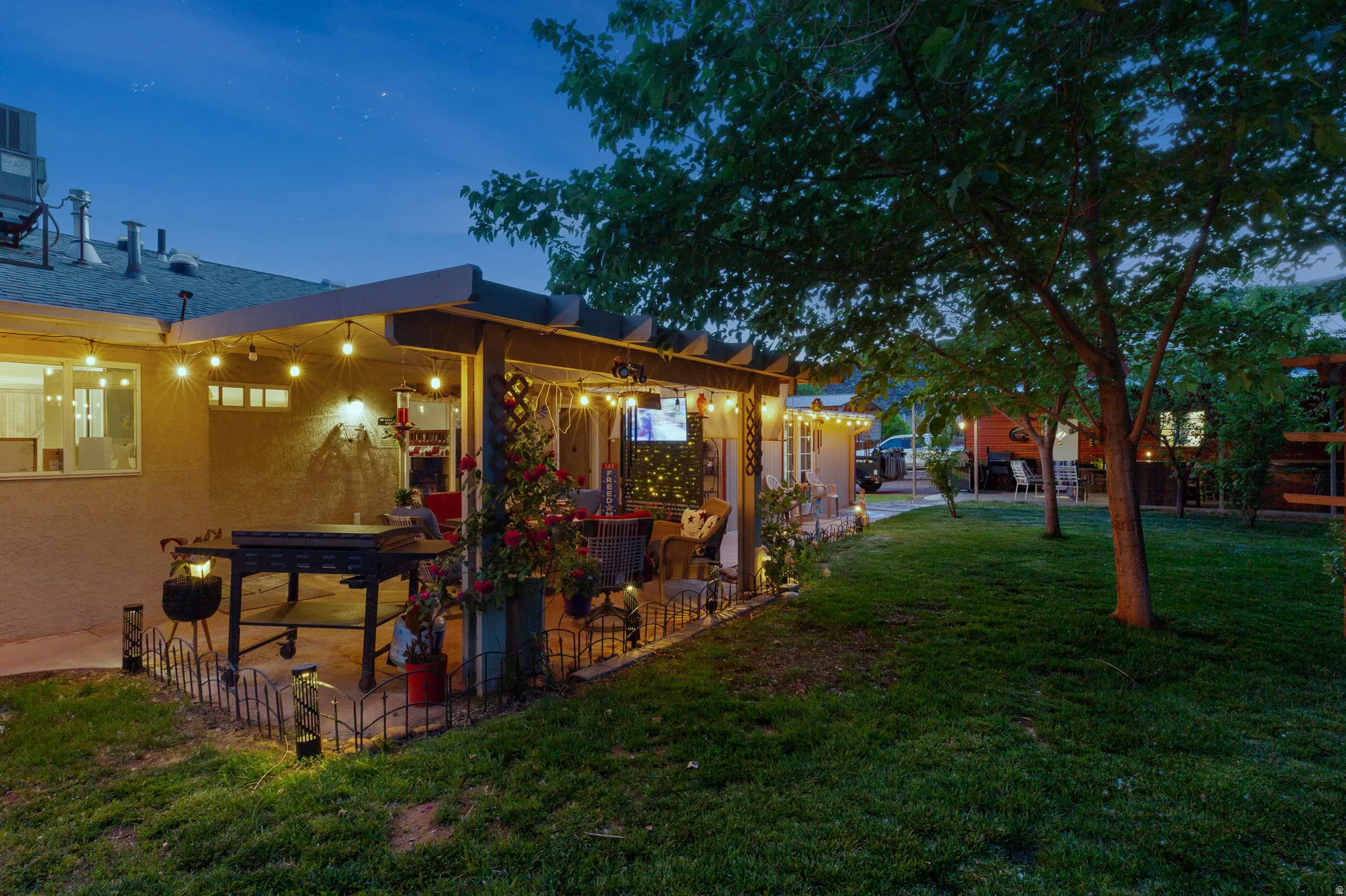 Covered patio featuring string lighting and a built-in entertainment area