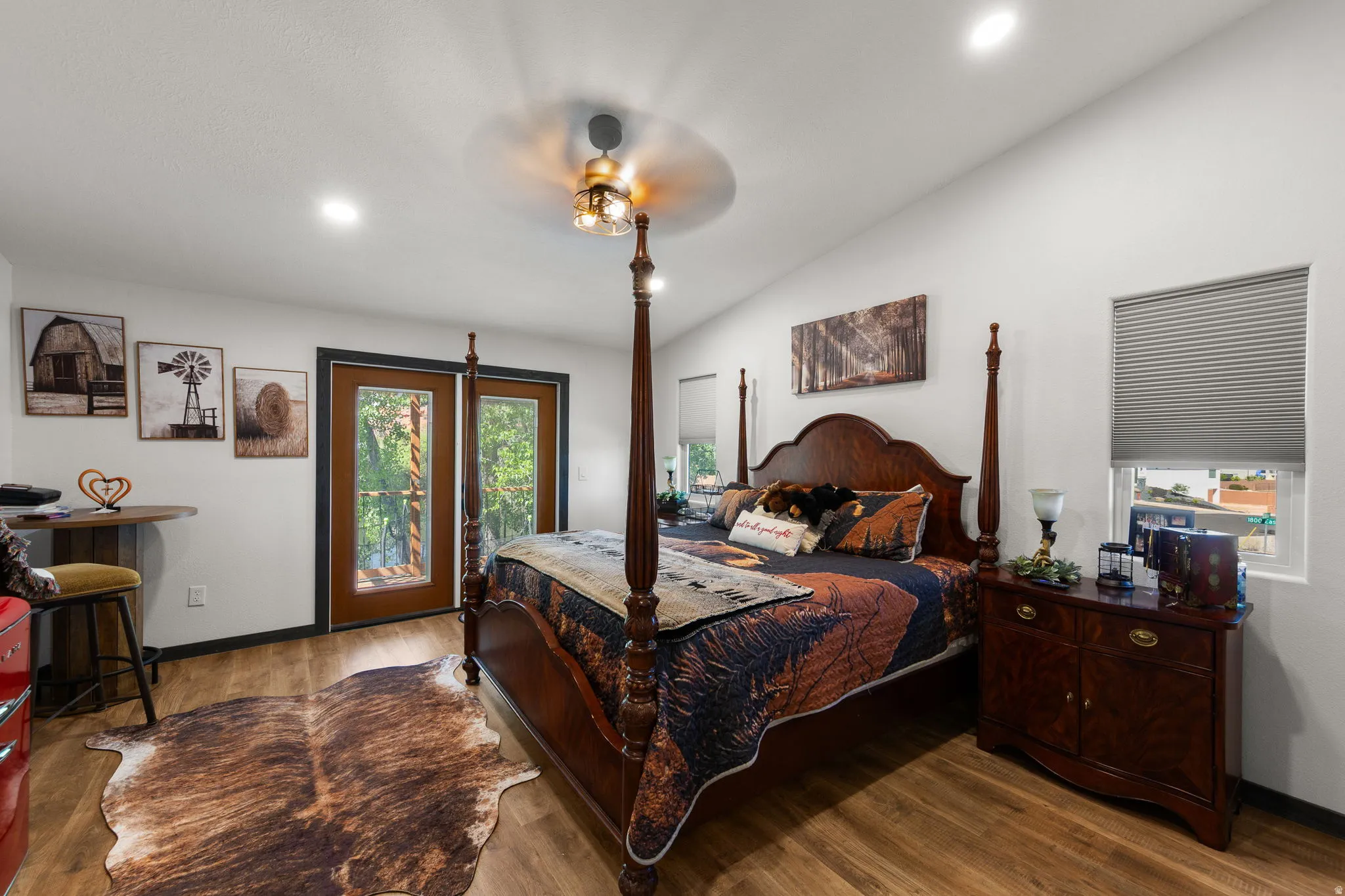 Interior space featuring wood-finish flooring, white walls, and a vaulted ceiling with a flush-mount light