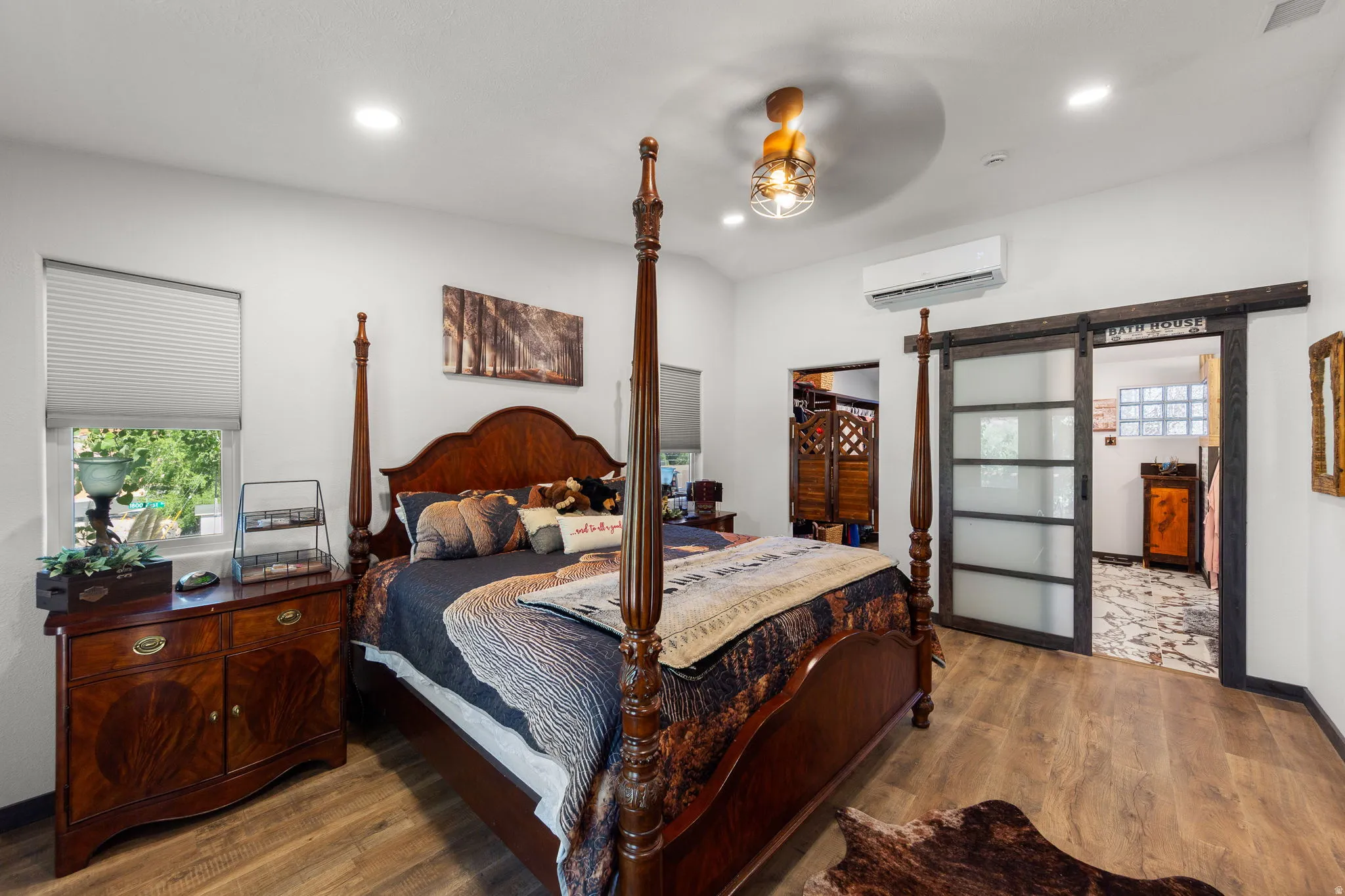 Bright bedroom featuring wood-finish flooring, recessed lighting, and a window with blinds