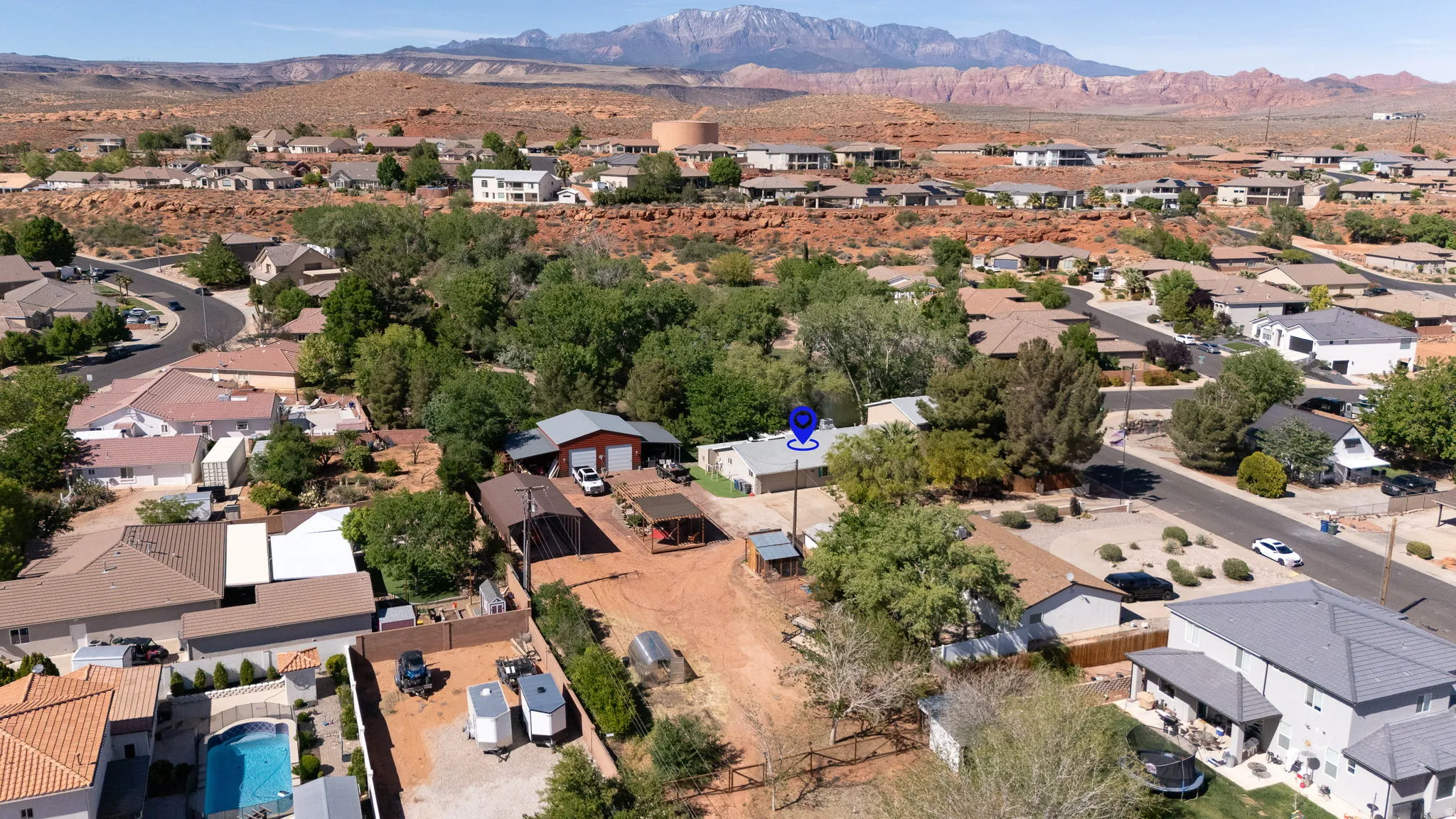Aerial overview showcasing a property with a red-roofed structure, surrounded by mature trees