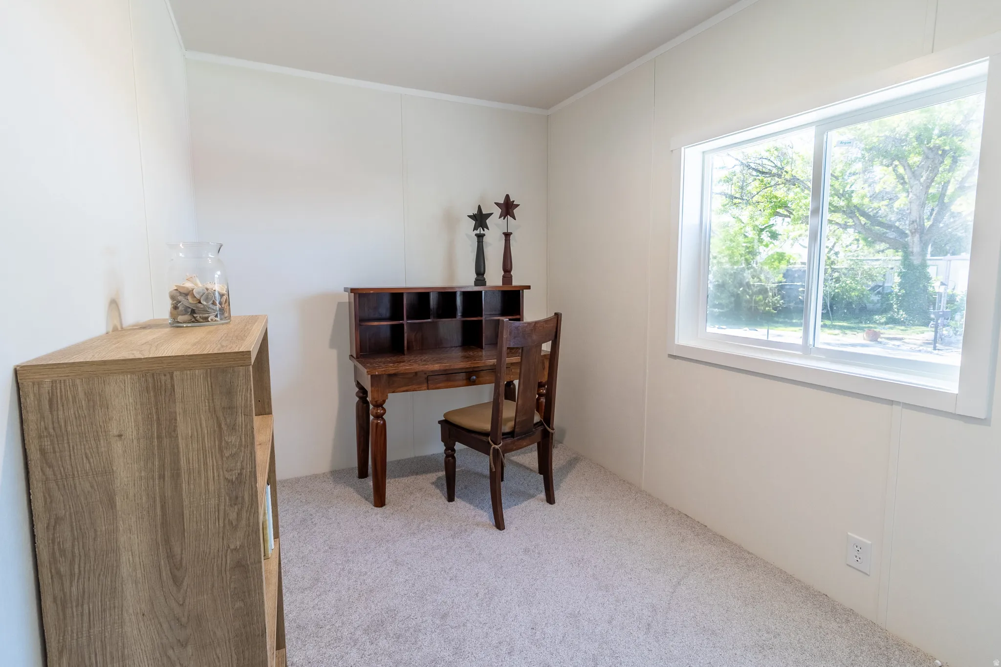 Home office with light colored carpet and crown molding