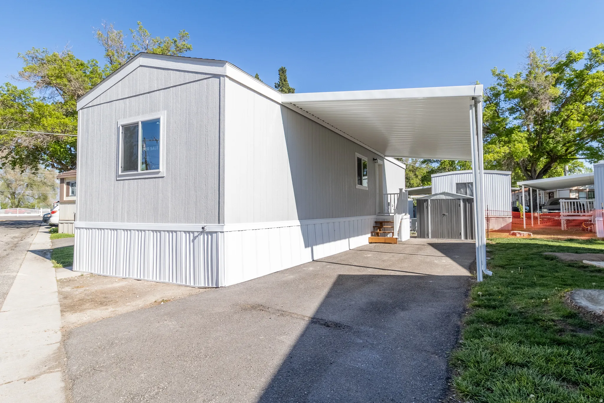 View of property exterior featuring a carport, driveway, and a shed