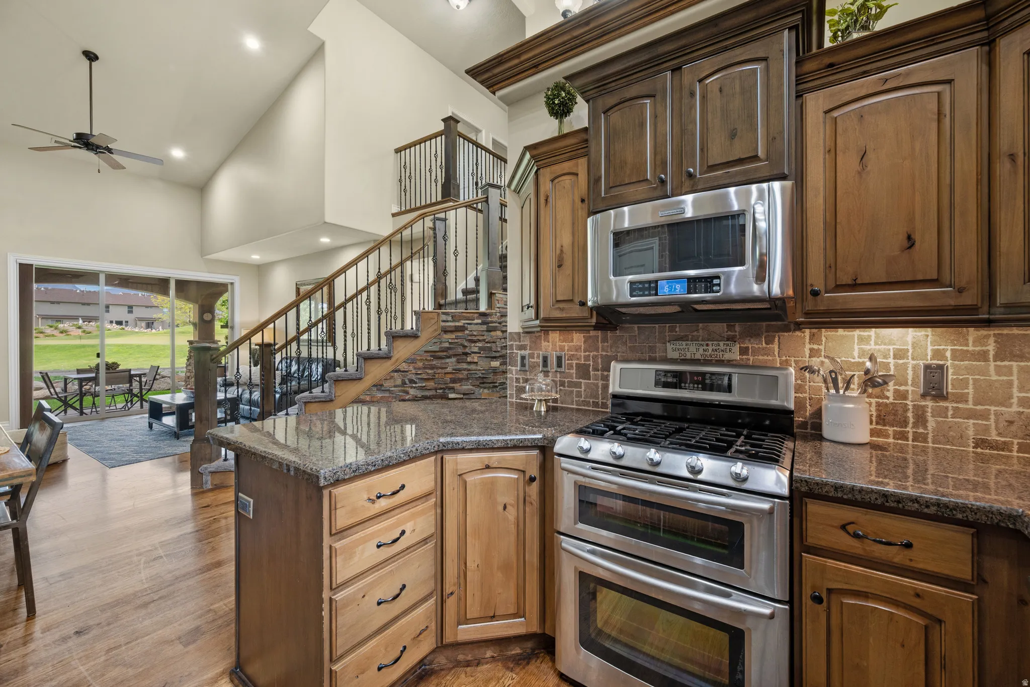 Gourmet kitchen featuring stainless steel appliances, granite countertops, and a tiled backsplash
