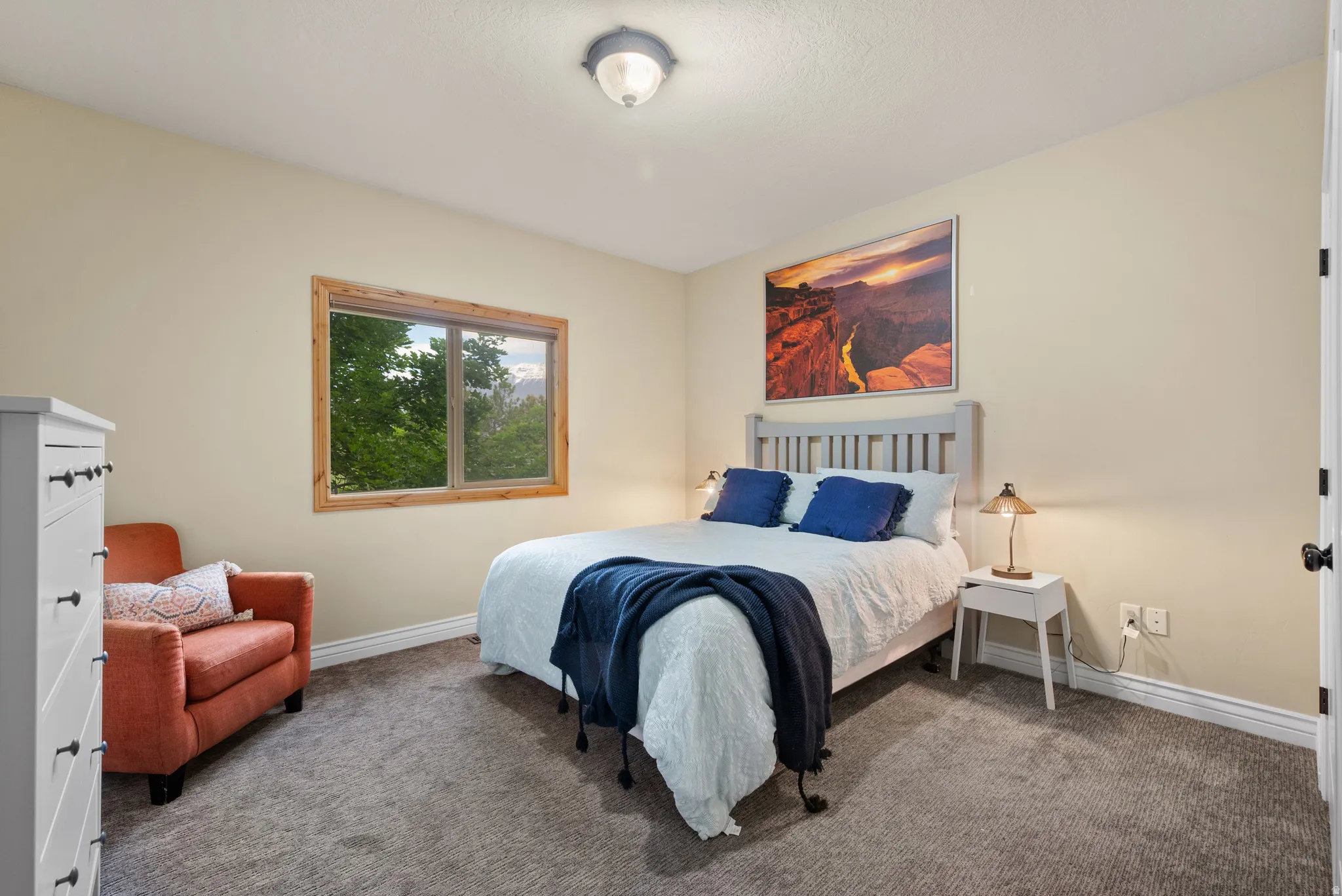 Carpeted room featuring a window with natural wood trim, light beige wall paint, white baseboards, and a semi-flush mount ceiling light
