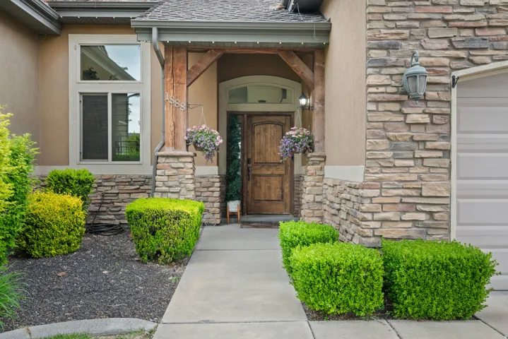 Stone veneer and stucco exterior with an arched wooden entry door