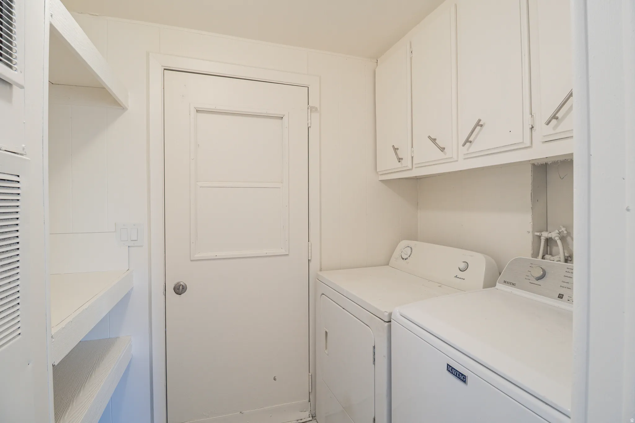 Dedicated laundry area with upper cabinetry and a side-by-side appliance setup