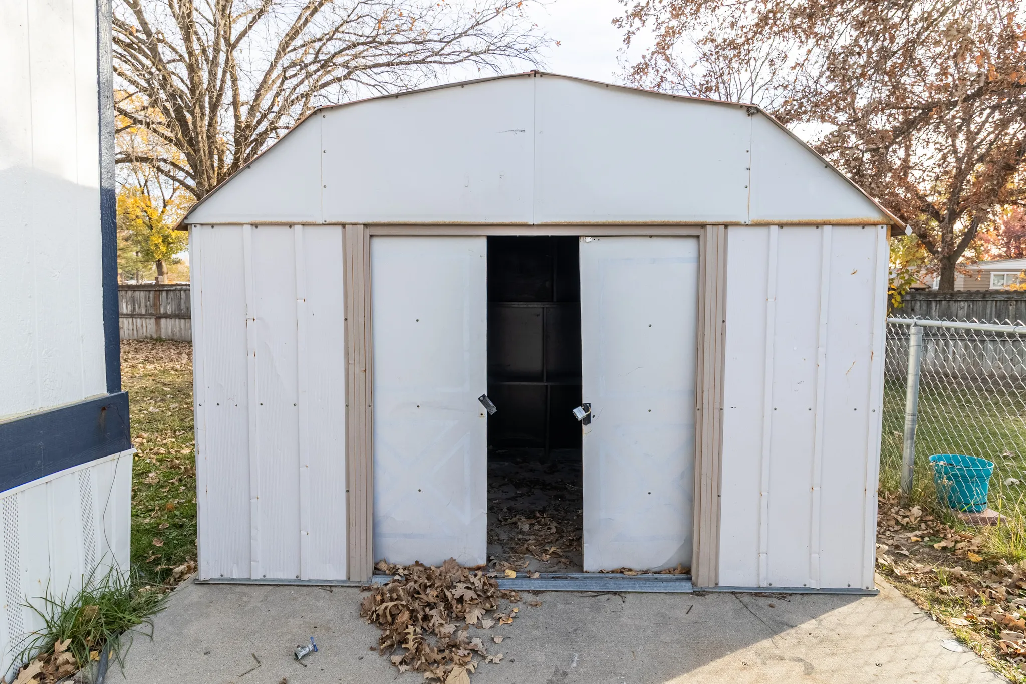 White metal storage shed with a gambrel-style roof