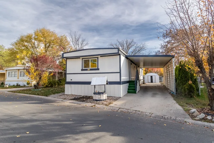 White siding property with dark trim accents and a covered carport