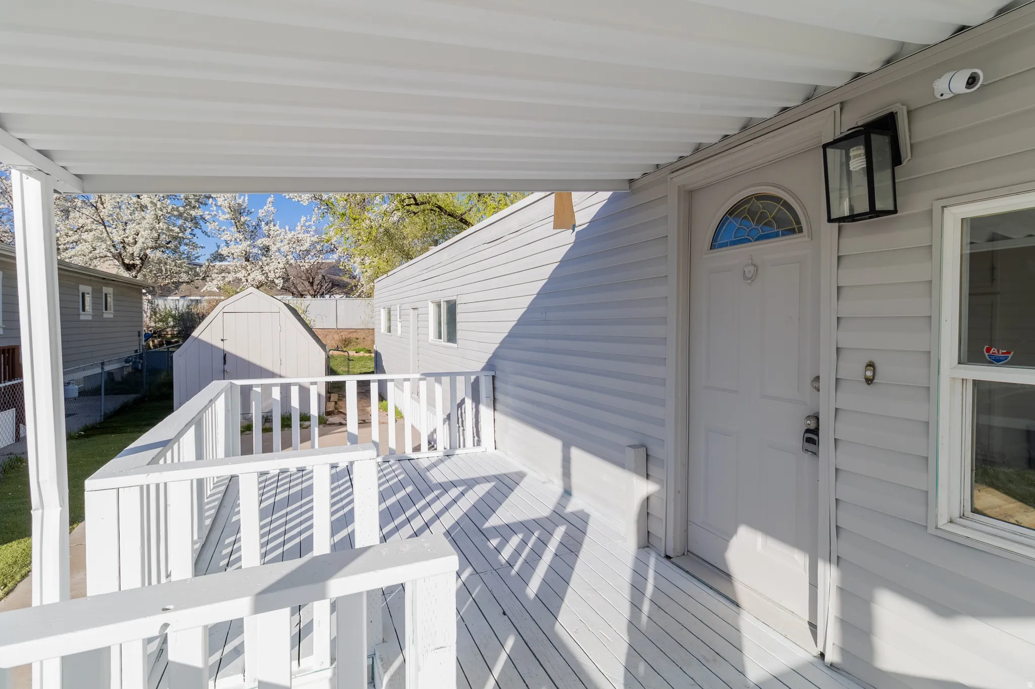 Covered front porch featuring white painted decking and railing