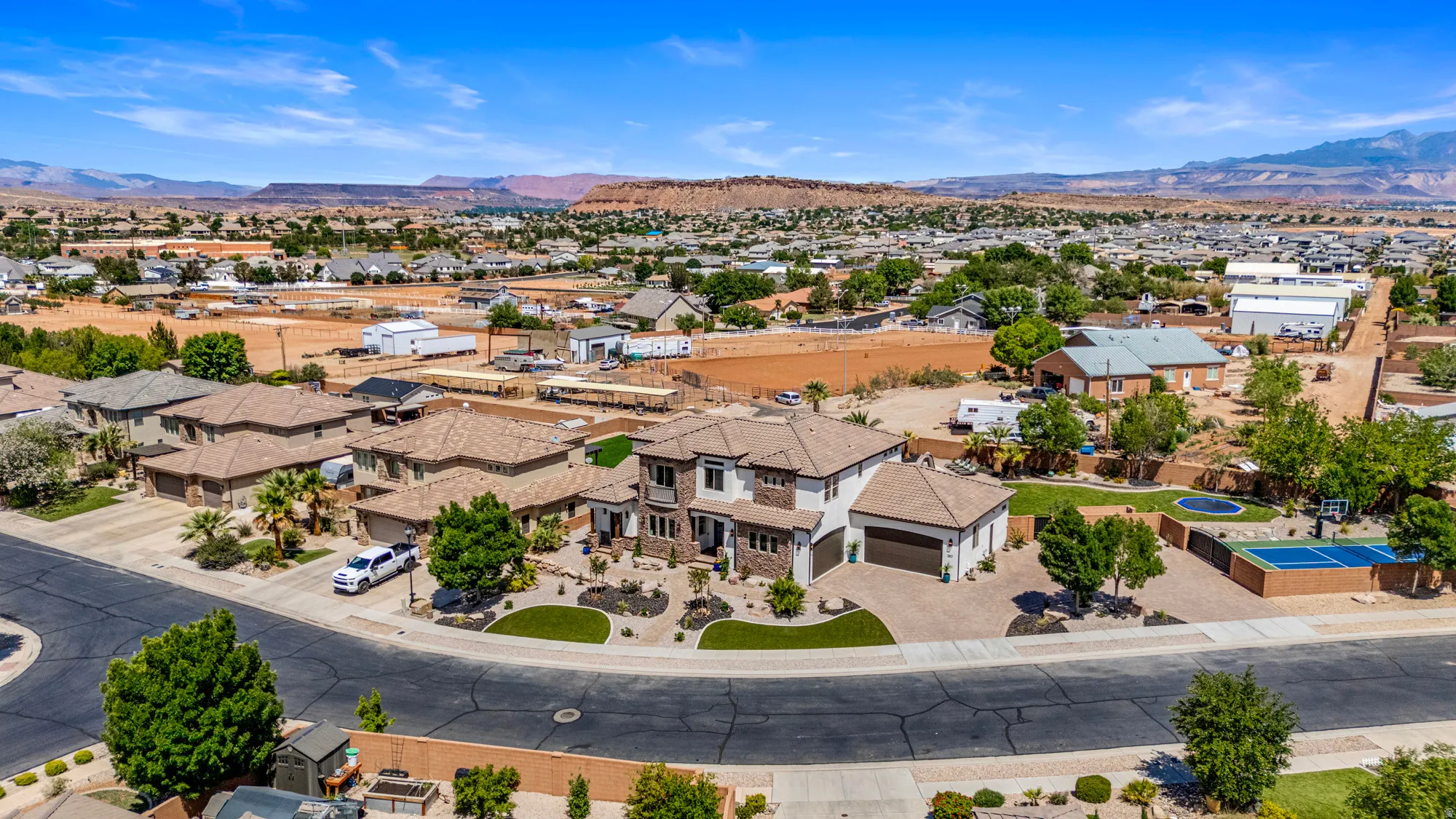 Spacious residential property featuring a stucco and stone exterior, multi-car garage, and desert-inspired landscaping