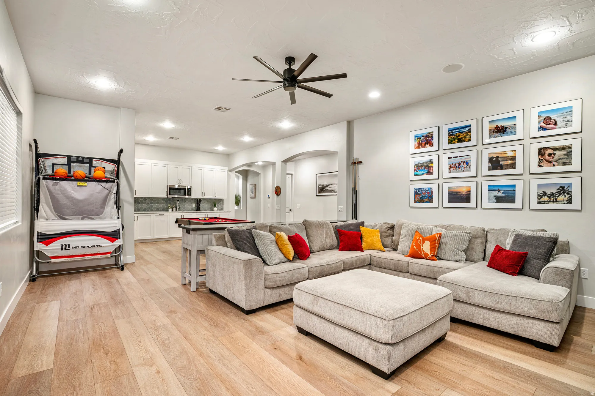 Light wood-finish flooring throughout, complemented by recessed lighting and a contemporary ceiling fan