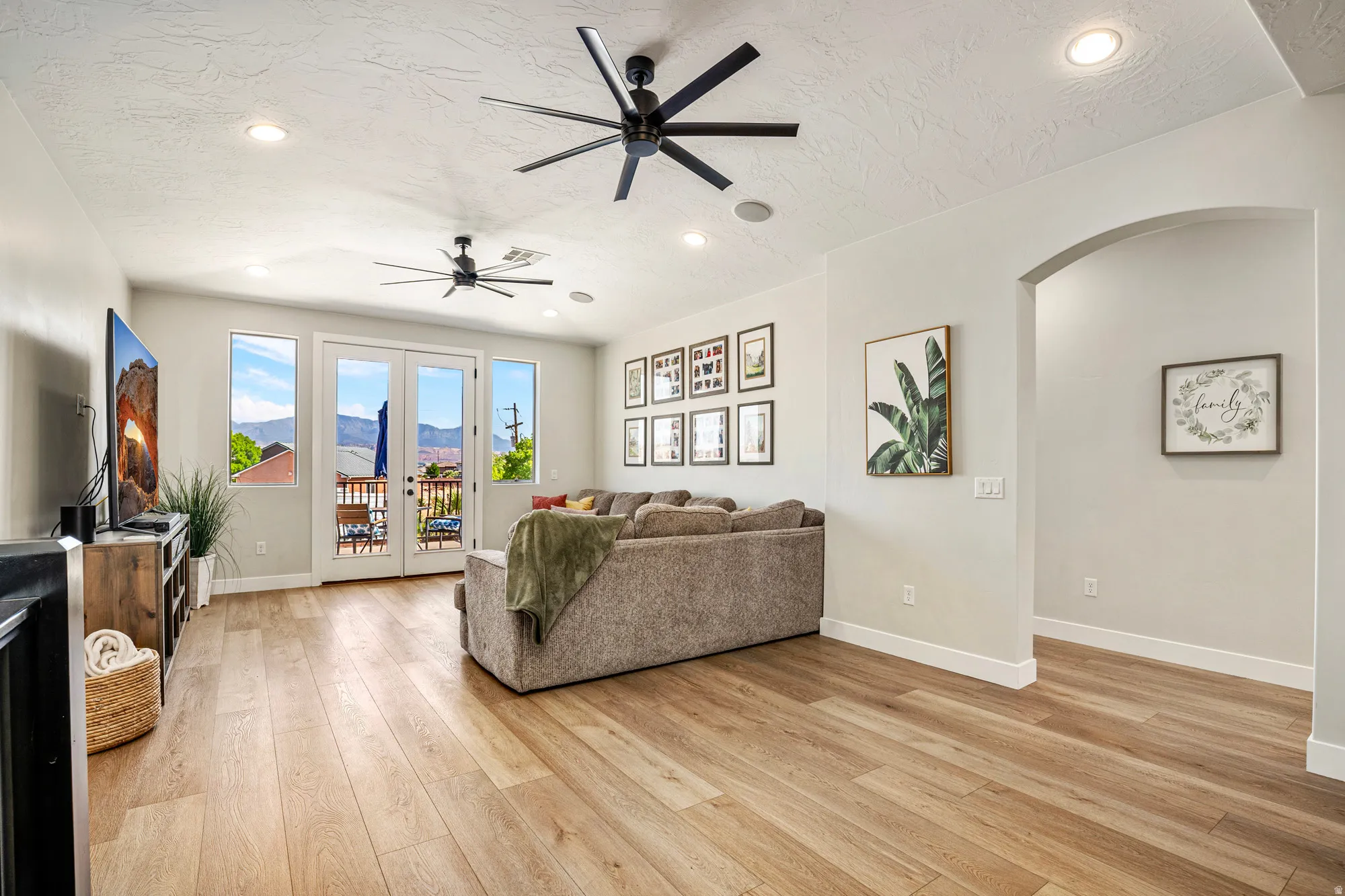 Open concept living area featuring wood-finish flooring, recessed lighting, and two contemporary ceiling fans
