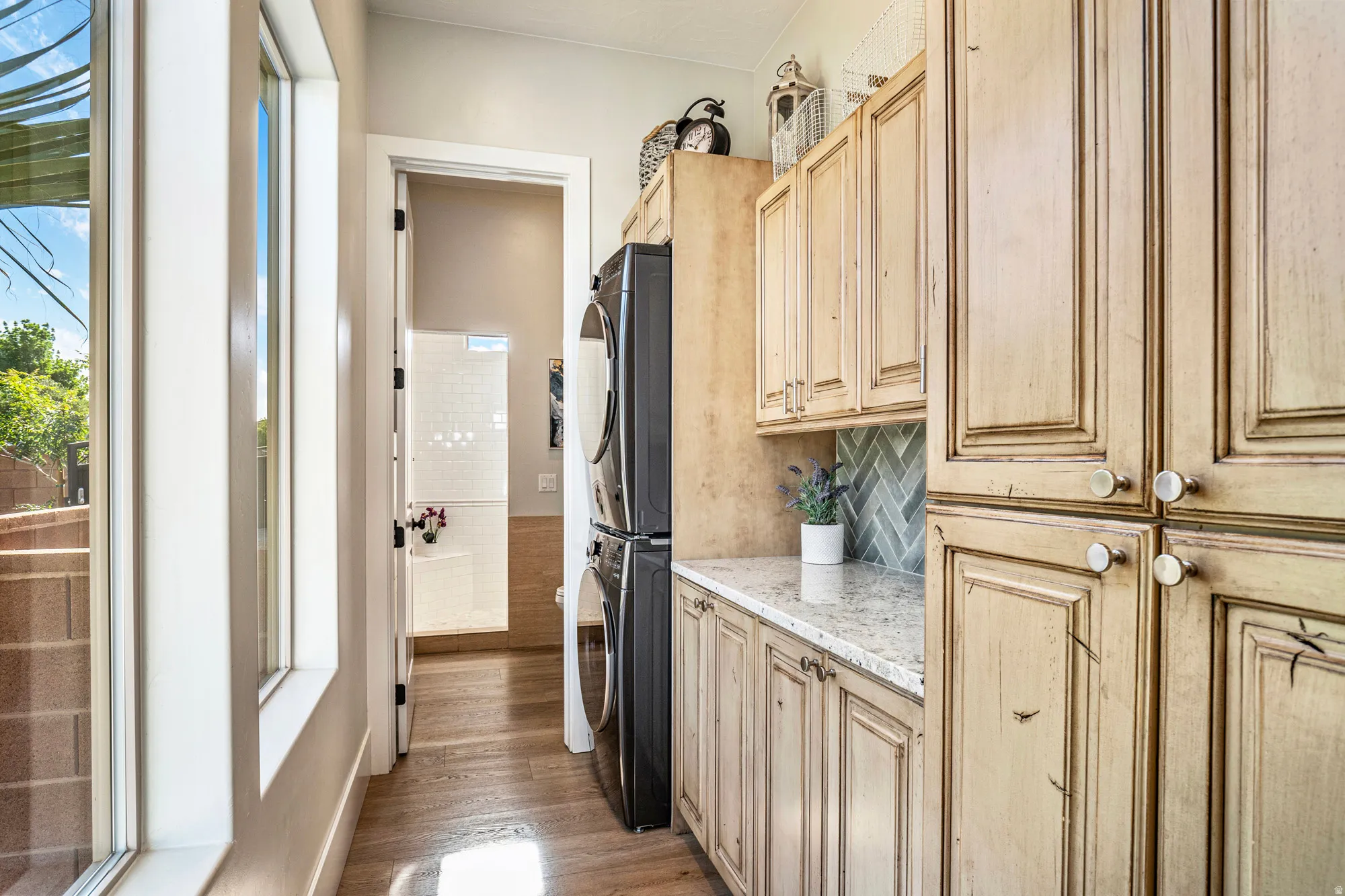 Laundry area featuring extensive cabinetry, light-toned countertops, and a herringbone tile backsplash