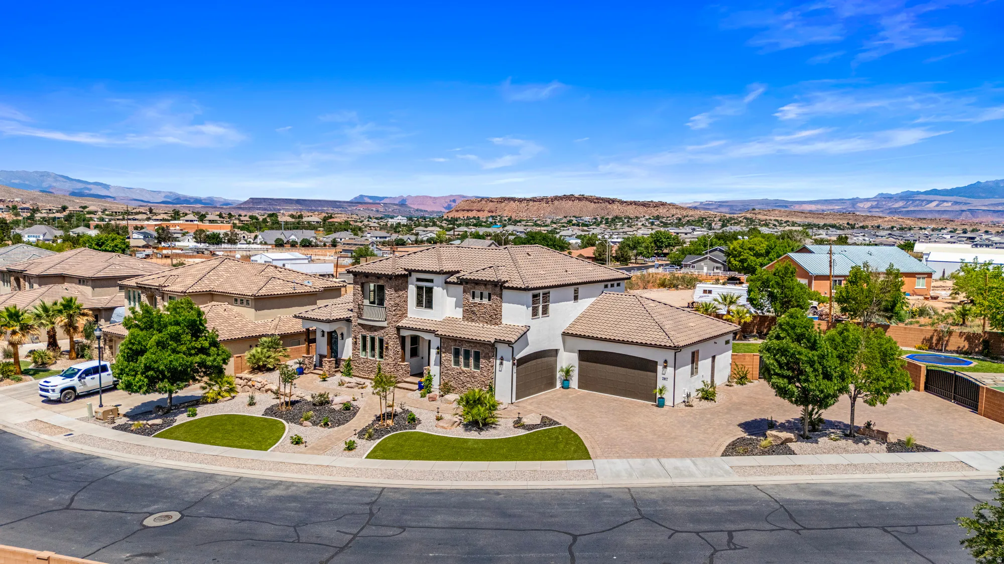 Contemporary Mediterranean-style residence featuring a tile roof, stucco and stone exterior, and an attached two-car garage